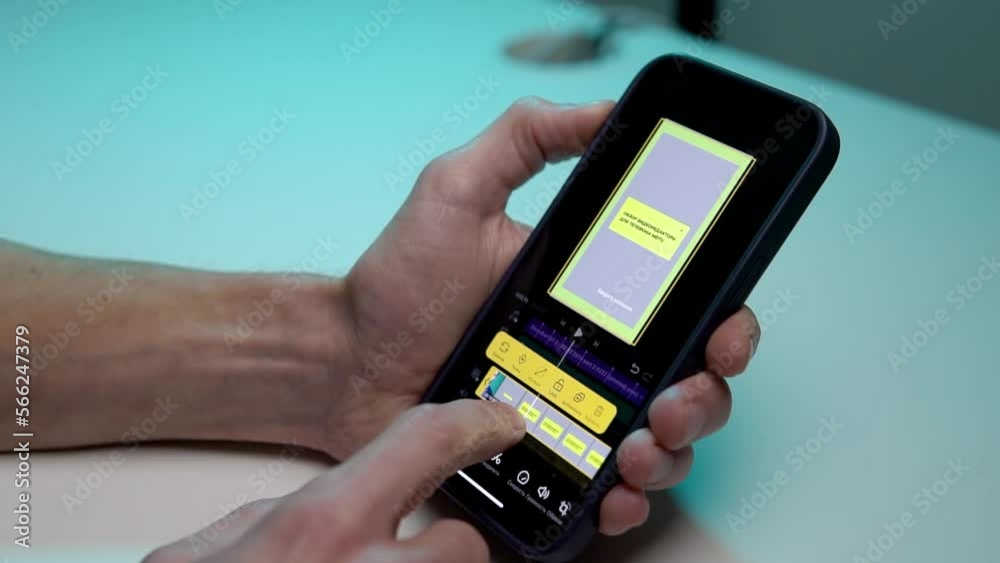 the video editor program on the phone. A young man is editing a video on his phone the video editor program on the phone. A young man is editing a video on his phone