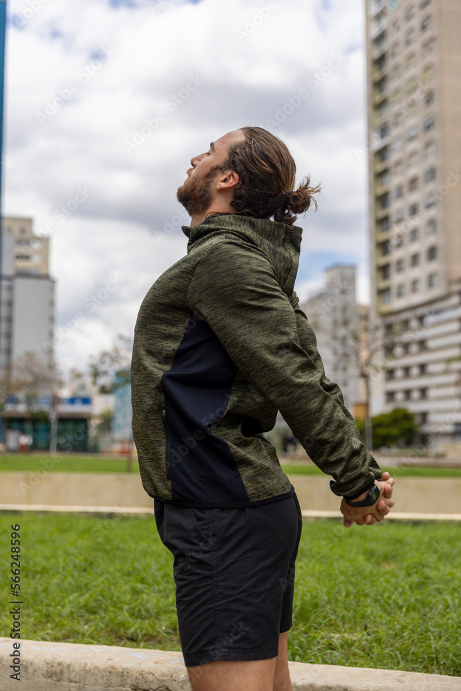 Brazil, Sao Paulo, Man in sports clothing stretching in city Brazil, Sao Paulo, Man in sports clothing stretching in city