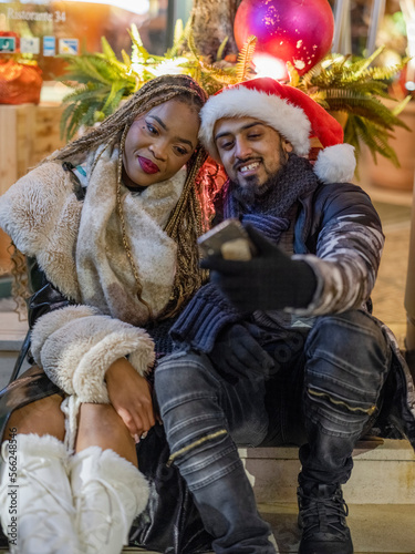 Young couple taking selfie with Christmas decorations
