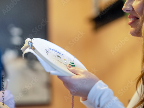 Smiling woman embroidering at home