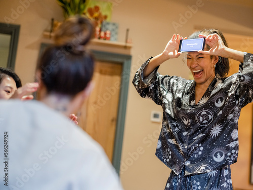 Friends playing charades during girls night at home photo