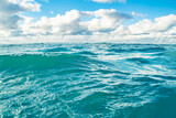 Panorama of a calm sea with clouds on the horizon. Background on the theme of summer vacation and ecology. Crystal clear ocean water.