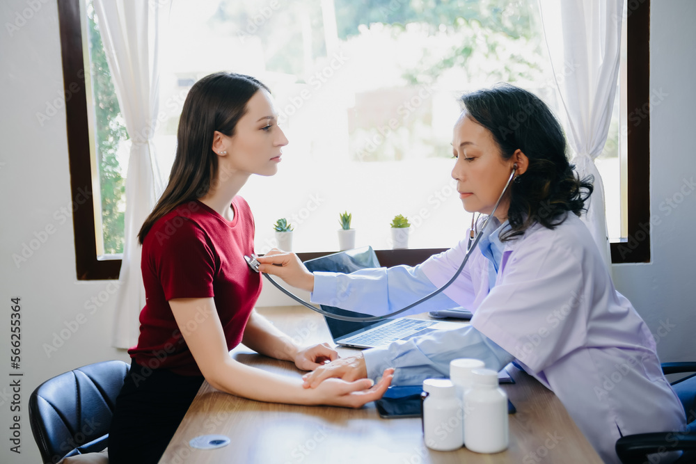 Fototapeta premium Woman being examined by a Senior doctor in background.