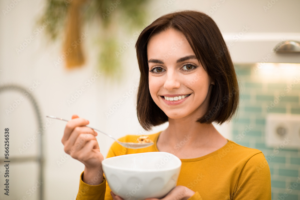 Closeup of cheerful young woman enjoying breakfast cereals at home Closeup of cheerful young woman enjoying breakfast cereals at home