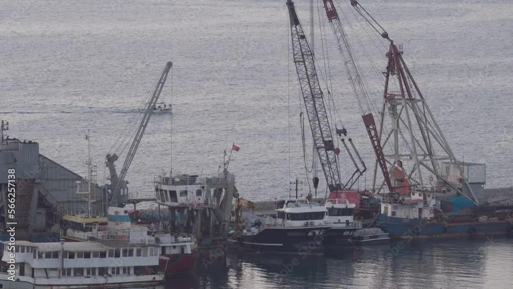Cranes and fishing boats in Iskenderun fishing port. Cranes and fishing boats in Iskenderun fishing port.