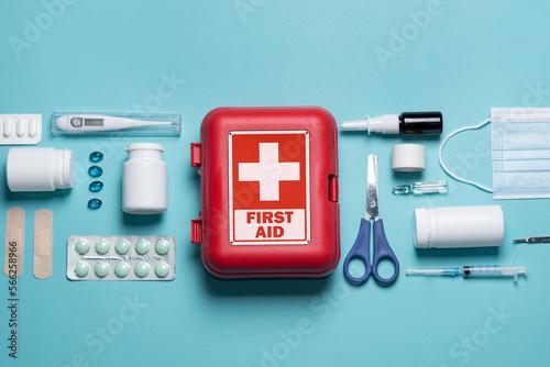 Home first aid kit on a blue background. The elements of the first aid