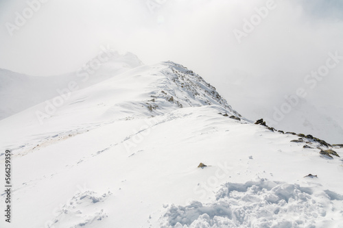 Mountain winter Caucasian landscape with a rocky peak in the frame on a cloudy foggy day, ski resort © yanik88