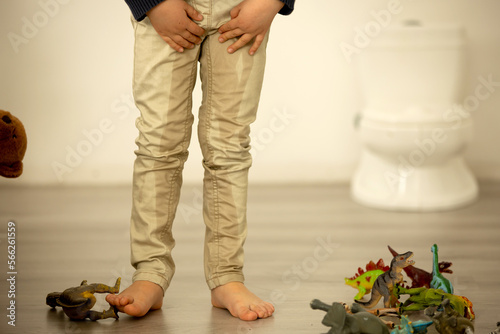 Little toddler child, boy, pee in his pants while playing with toys, child distracted and forget to go to the toilet