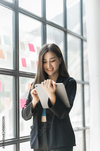 Pretty asia business woman bookkeeper brainstorming and working in modern office workplace with sticky notes or post it at windows. © M+Isolation+Photo