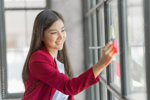 Pretty asia business woman bookkeeper brainstorming and working in modern office workplace with sticky notes or post it at windows. Free Download Pretty asia business woman bookkeeper brainstorming and working in modern office workplace with sticky notes or post it at windows. - GFXLoad