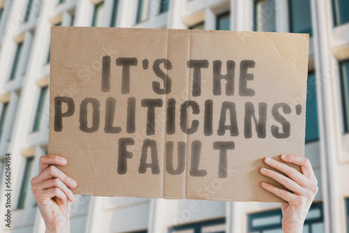 Quadro em tela The phrase  It's politicians' fault  is on a banner in men's hands with blurred background