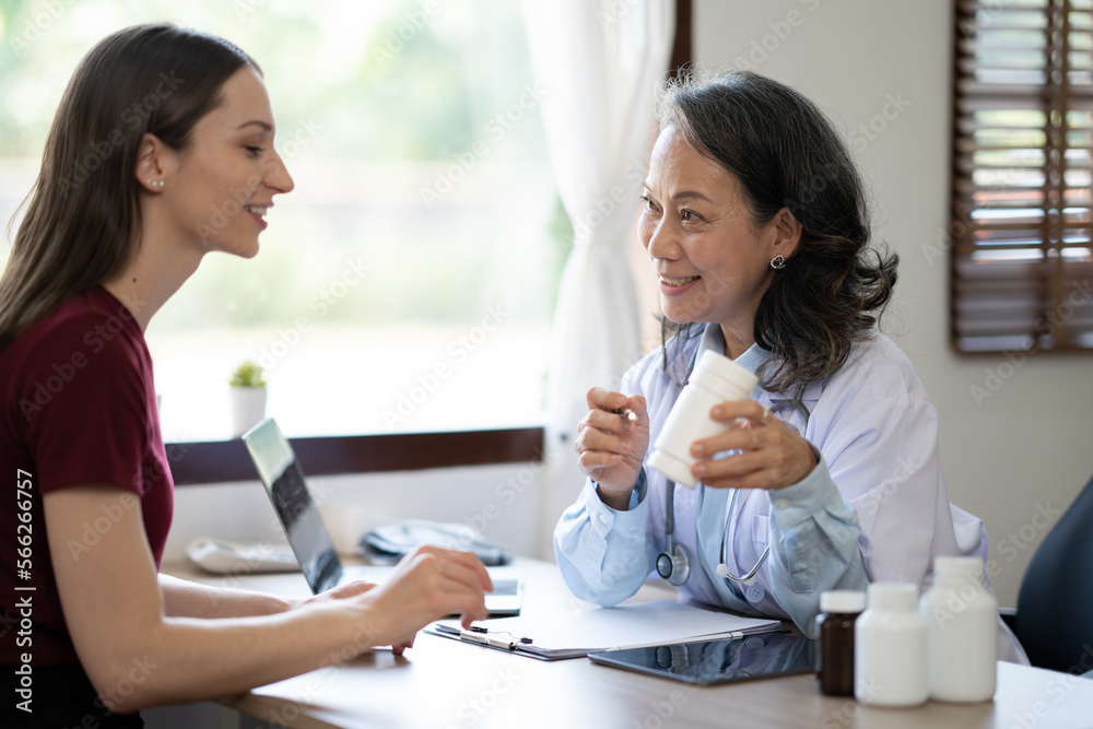 Senoir female doctor explaining bottle of medicine to her young patient. Senoir female doctor explaining bottle of medicine to her young patient.