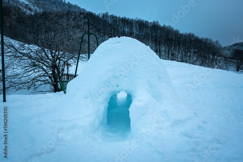 Pequena casa feita de neve a meio da montanha e florestas num dia frio de inverno © LuIvDa