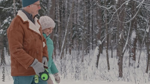 Wallpaper Mural Active senior couple chatting while walking their dog in winter forest Torontodigital.ca