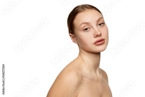 Half-length portrait of young beautiful girl without makeup on face. Model with bare shoulders. Concept of purity, skin care, beauty, spa, anti-aging procedures