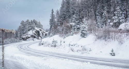 Slipery country road in snowy forest in winter. No cars.Bad driving conditions. Scandinavia.