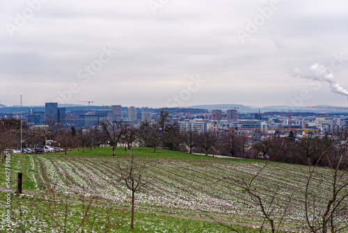 Scenic landscape with concrete chimney with smoke of power plant at City of Zürich district Schwamendingen on a cloudy winter day. Photo taken January 29th, 2023, Zurich, Switzerland.