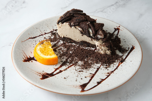 closeup shot of an oreo pudding with sliced orange in the side on a white plate