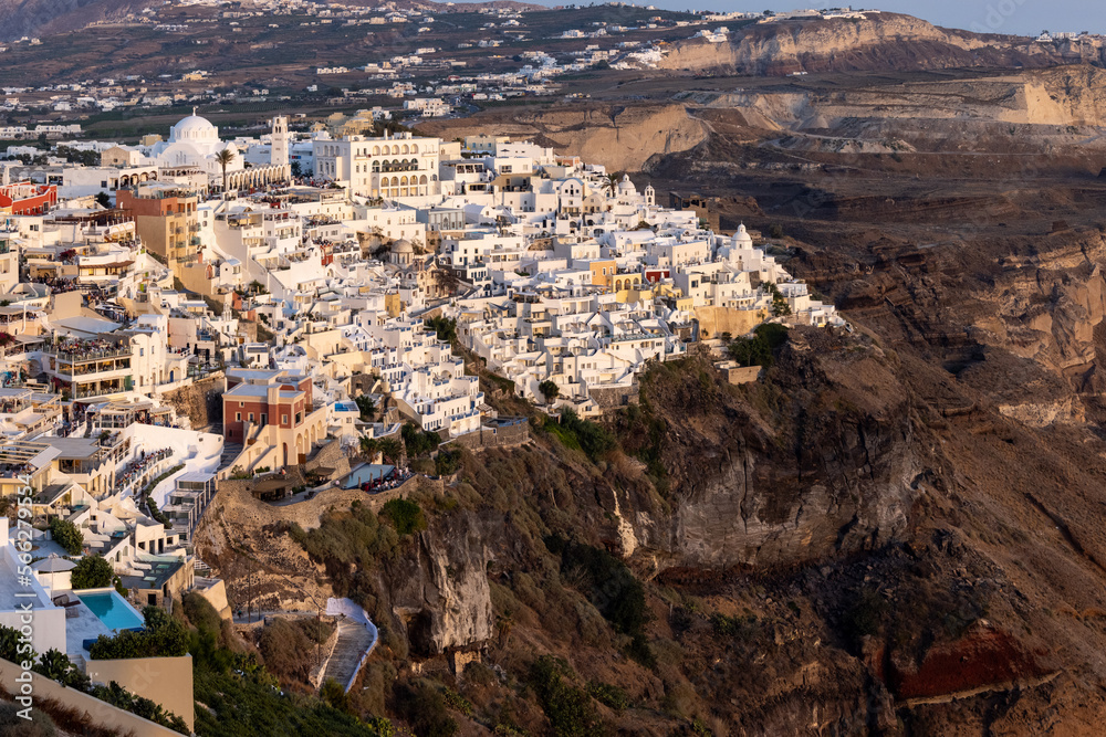 The whitewashed town of Fira in warm rays of sunset on Santorini island, Cyclades, Greece