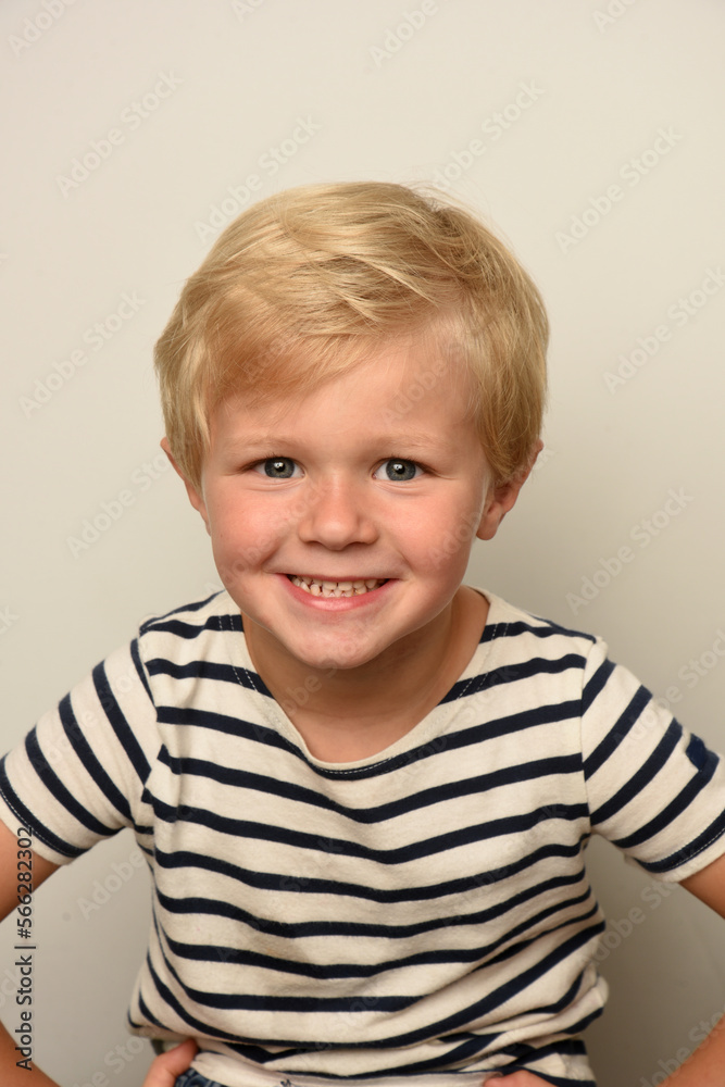 young blond child smiling with a striped sailor young blond child smiling with a striped sailor