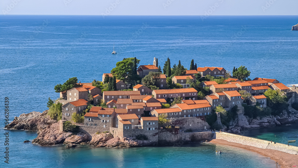 Panoramic view of idyllic island Sveti Stefan in Bay of Budva, Adriatic Mediterranean Sea, Montenegro, Europe. Summer vacation in exclusive luxury hotel complex resort at the seaside. Medieval town