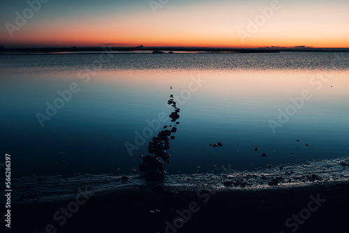 Misty seascape - calm water surface of the lake reflects lilac sky with pink and blue clouds after sunset. White nights season in the Republic of Karelia, Russia. Blur filter, space for copy. © simona