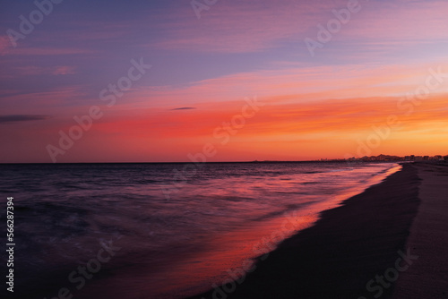 Red color Sunset or sunrise sky clouds over sea sunlight in beautiful travel destination Amazing nature landscape seascape Colorful sky background. Copy space. Island in background. Blue ocean.