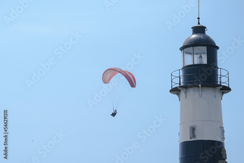 Close up lighthouse and paraglider  in Miraflores Lima Peru. Person is paragliding in Miraflores Lima Peru with lighthouse. Selective focus. Open space area.	 photo