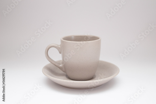 Grey ceramic and saucer on a white background