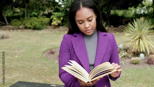 Young woman reading a book sitting on a bench. photo