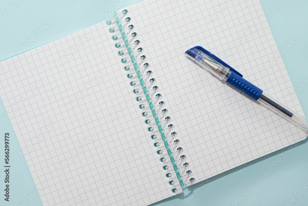 Top view of blank notepad with pen handwritten copy space. Glider notepad blank. Notebook in a cage for notes. Top view of blank notepad with pen handwritten copy space. Glider notepad blank. Notebook in a cage for notes.