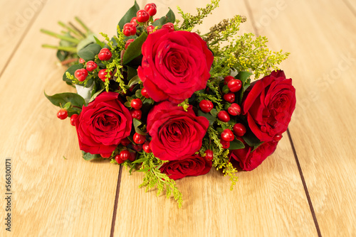 Closeup red roses lying on wooden background. 