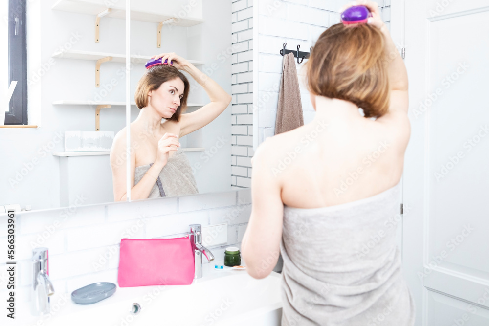 Attractive young woman putting on makeup after taking a shower in the bathroom Attractive young woman putting on makeup after taking a shower in the bathroom