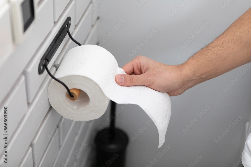 Close-up of Hand using a toilet paper. Hygiene and self care concept Close-up of Hand using a toilet paper. Hygiene and self care concept