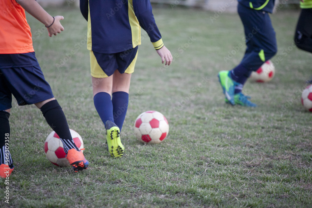 football game with boys intent on kicking a ball during training on a clay field football game with boys intent on kicking a ball during training on a clay field
