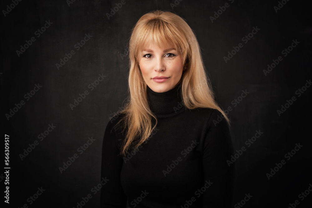 Studio portrait of blond haired woman standing at isolated background