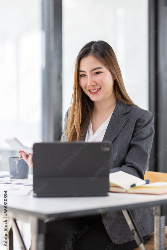 Young business Asian woman is sitting at table, working on laptop with graphs, charts, money and report financial concepts. Online marketing, education, analytics, e-commerce, business planning Young business Asian woman is sitting at table, working on laptop with graphs, charts, money and report financial concepts. Online marketing, education, analytics, e-commerce, business planning