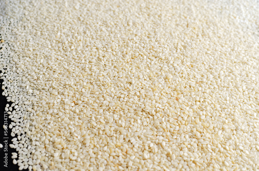 sesame seeds scattered on a black background. Concept of healthy food. Horizontal orientation sesame seeds scattered on a black background. Concept of healthy food. Horizontal orientation