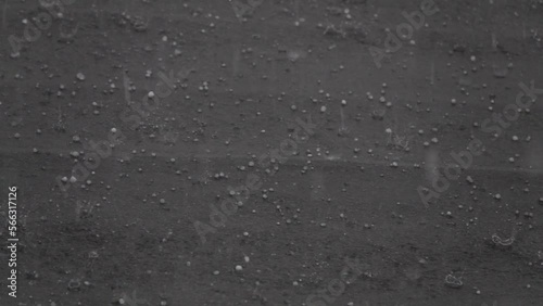 Slow motion of hail storm hitting roof during a bad weather summer storm