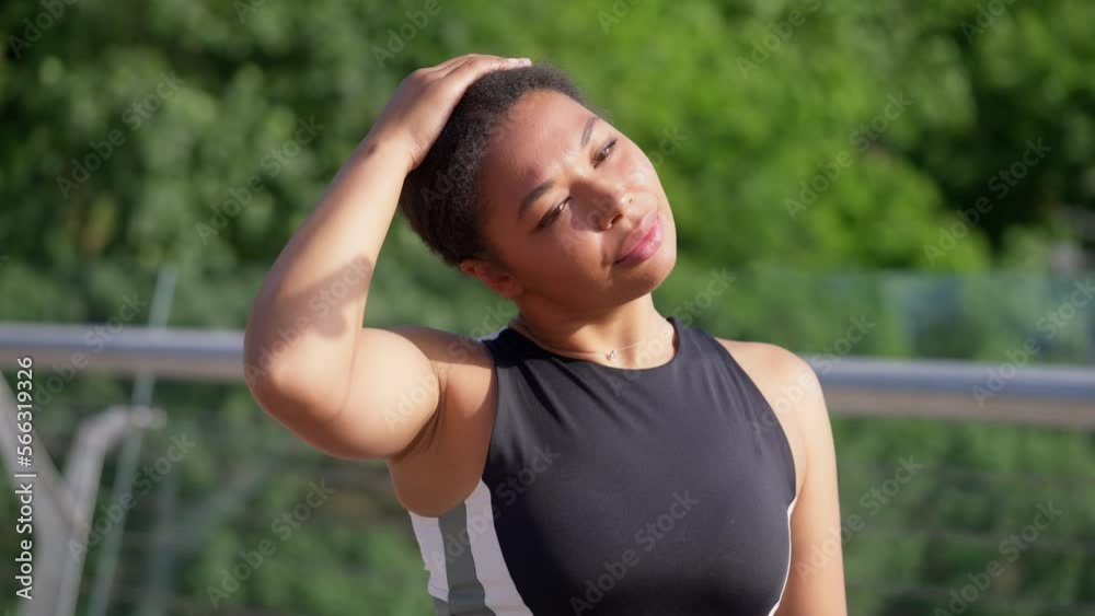 Young African American female athlete doing neck exercise before jogging, sports Young African American female athlete doing neck exercise before jogging, sports