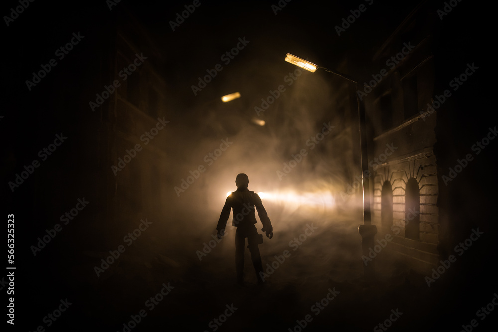 Sad man alone walking along the alley in night foggy park. Decorative ruined city.