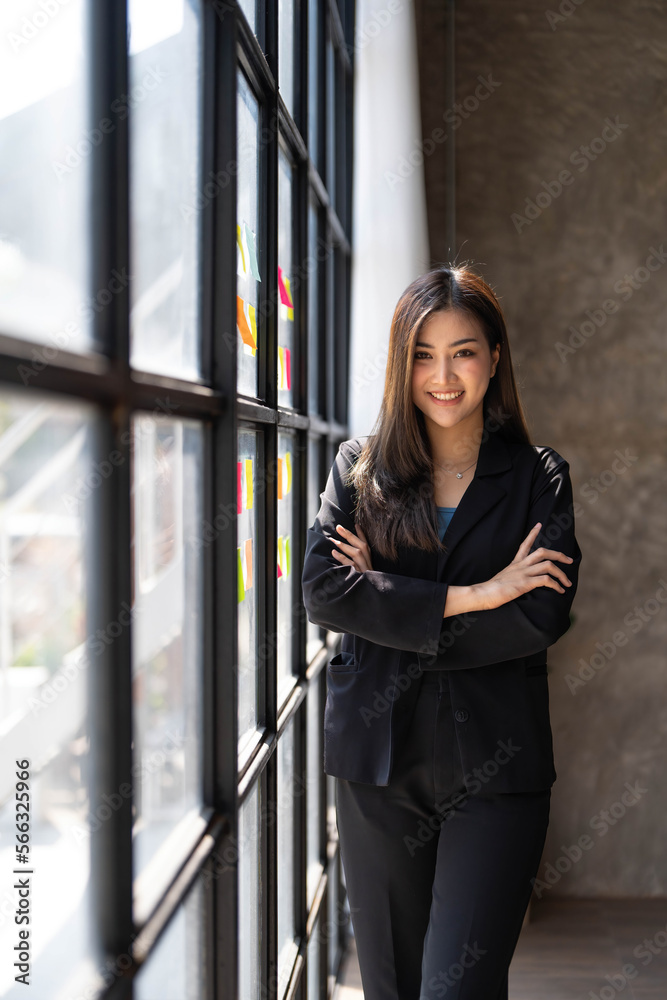 Young business woman standing to drinking coffee and thinking about the strategy of new startup while looking out the window in modern office. Young business woman standing to drinking coffee and thinking about the strategy of new startup while looking out the window in modern office.