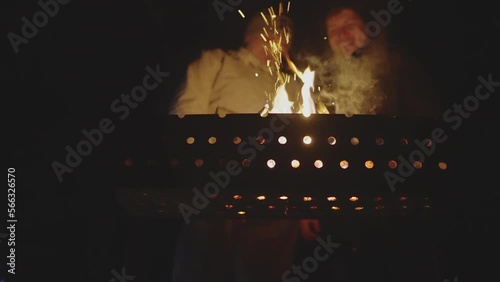 Two men are talking over a brazier. Focus on the brazier