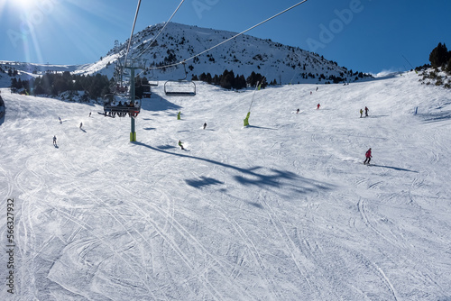 Ski slope with skiers sliding down the slope in the Pyrenees, Andorra, photo with copyspace. photo