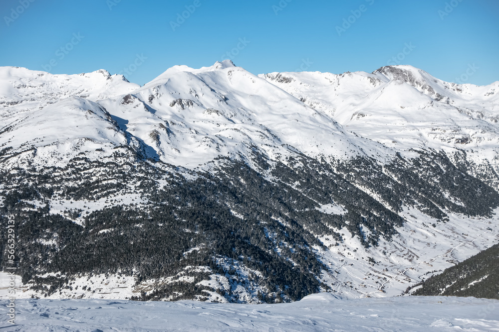 Snowy landscape with trees and high mountains in the mountain range of the Pyrenees, Andorra.