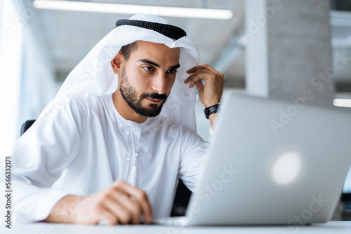 Photography handsome man with dish dasha working in his business office of Dubai