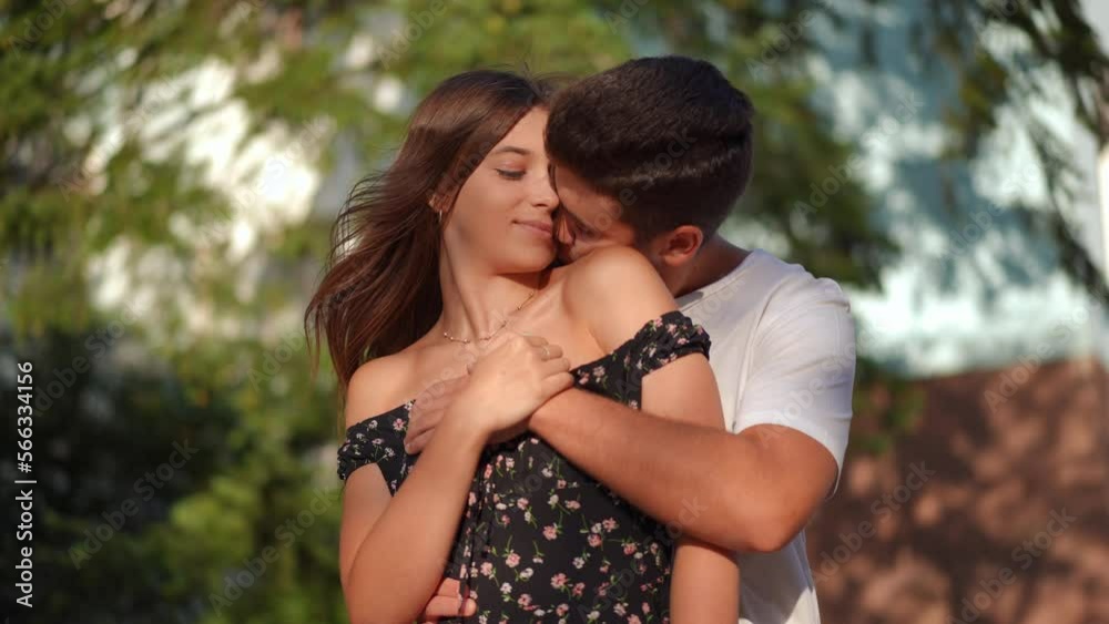 Portrait of satisfied loving young couple cuddling on city street enjoying dating on spring summer day. Happy carefree Caucasian boyfriend and girlfriend hugging smiling standing outdoors at sunset Portrait of satisfied loving young couple cuddling on city street enjoying dating on spring summer day. Happy carefree Caucasian boyfriend and girlfriend hugging smiling standing outdoors at sunset