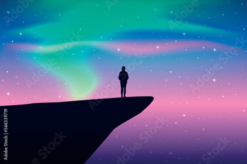 girl on a cliff looks in the colorful starry sky with aurora borealis