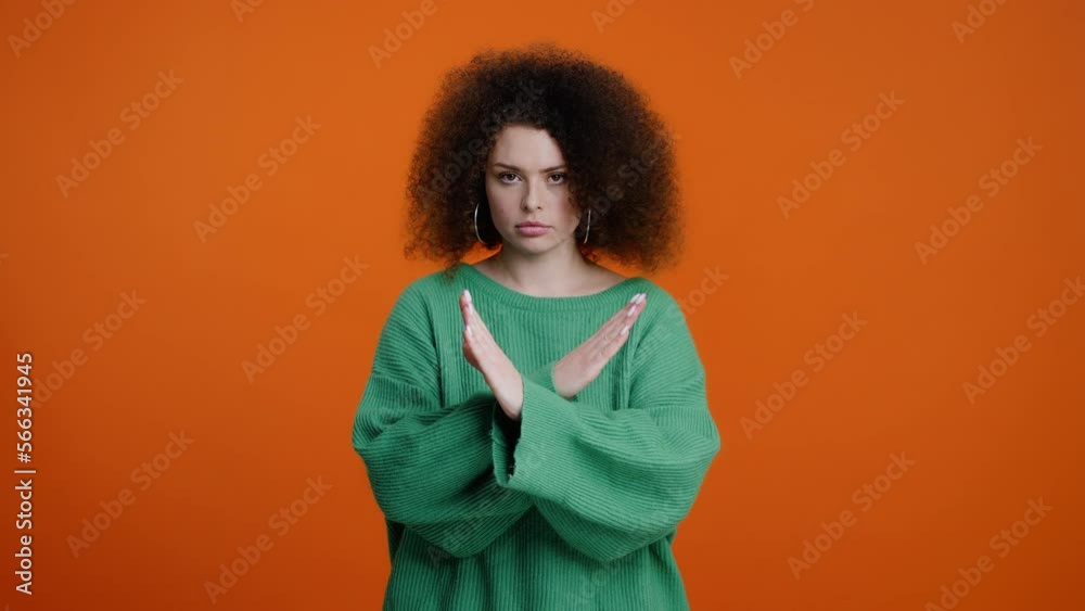 Worried anxious young woman, gesturing with her hands, showing Stop sign on orange background Worried anxious young woman, gesturing with her hands, showing Stop sign on orange background