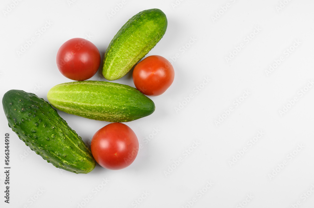 Layout of ripe tomatoes and cucumbers on a white background. The concept of cooking, organic vegetables. Layout of ripe tomatoes and cucumbers on a white background. The concept of cooking, organic vegetables.